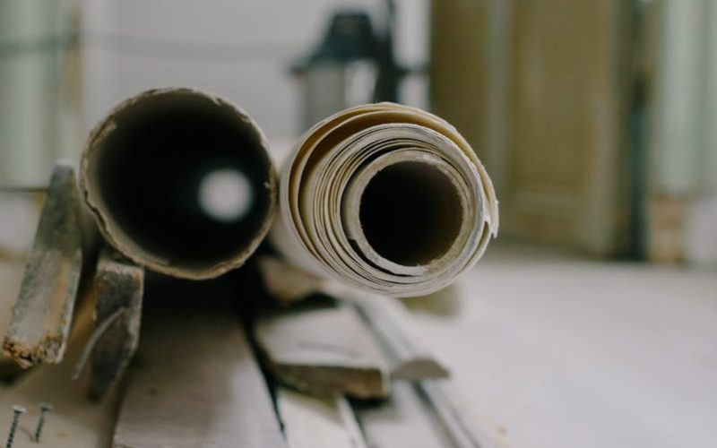 Close-up of renovation materials in an indoor setting with a focus on tubes and planks.