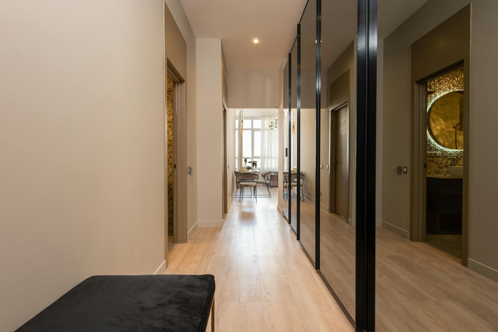 Elegant hallway in a modern apartment featuring large mirrors and natural light.