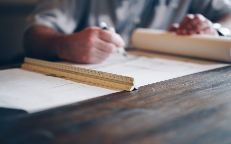 person drafting on blueprint