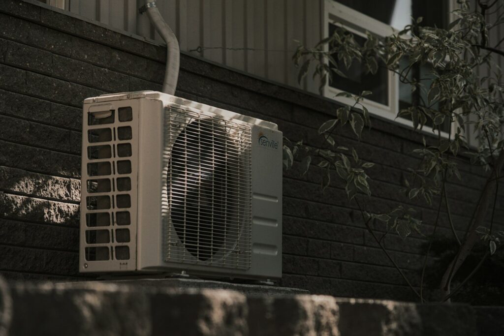 a white air conditioner sitting on top of a brick wall